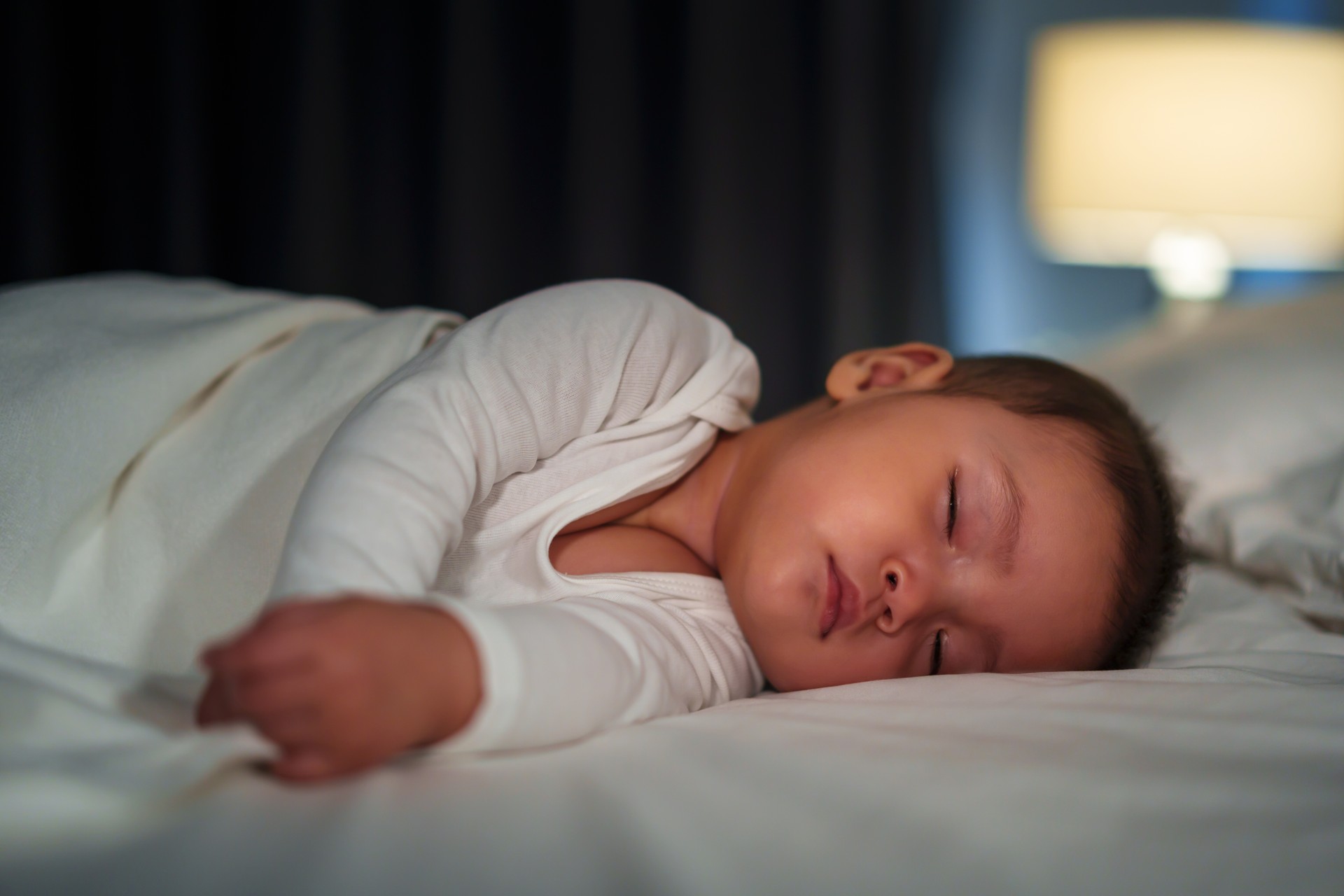 infant baby sleeping on bed at night